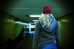 Young person walking in a dark tunnel
