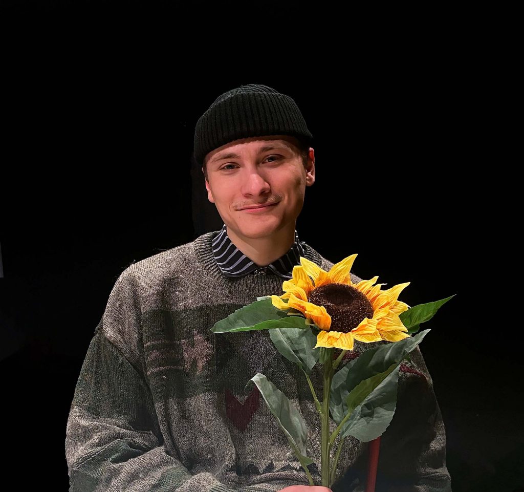 Kuvassa on Joni Hakala auringonkukan kanssa.