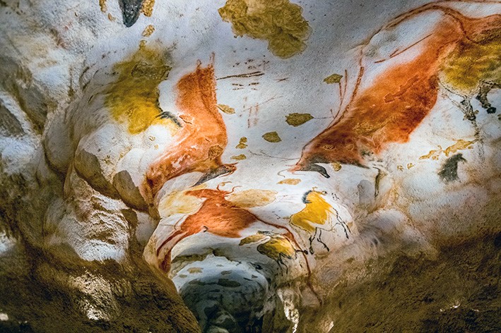 Kuvassa näkyy luolan katossa olevia ikivanhoja maalauksia, eläinhahmoja.