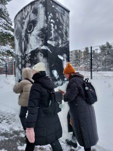 Kolme opiskelijaa talvella kävelemässä VR-suunnistustilanteessa Varissuon lähiössä.