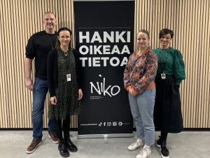 Neljä hankkeen toimijaa asettuneina Niko-hankkeen julisteen eteen