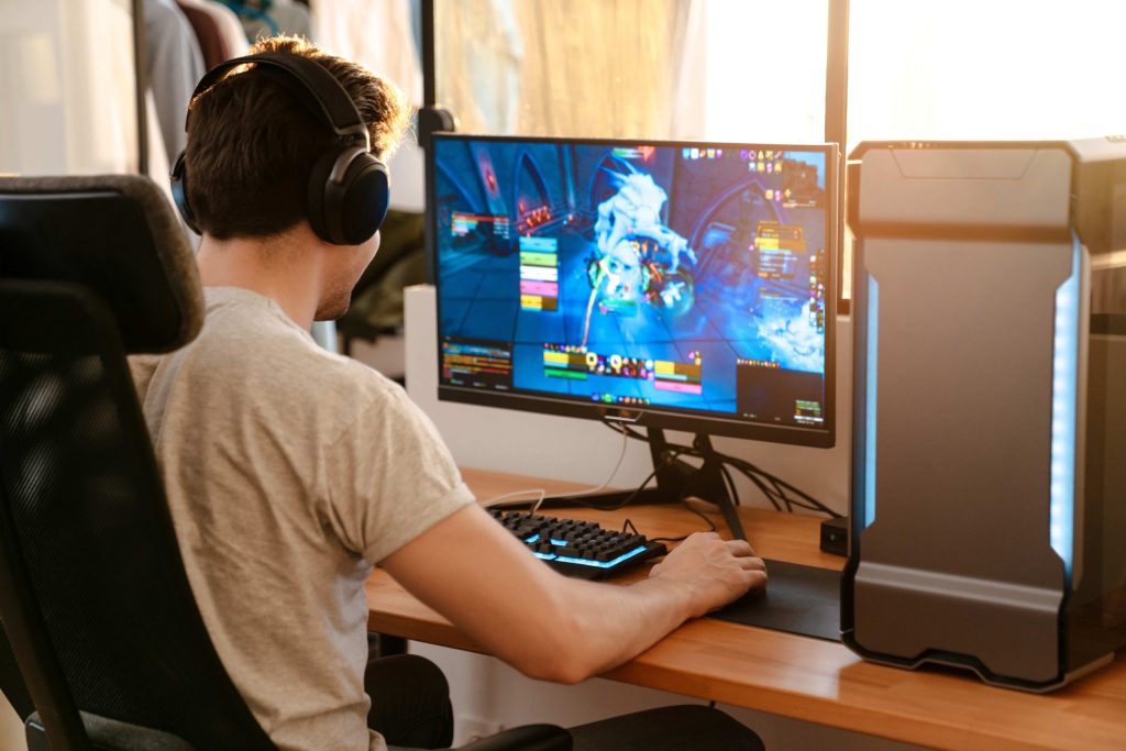Poika pelaa verkkopeliä pöytäkoneella. Adobe Stock photo
