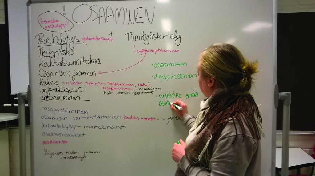A woman writes on a flip chart.