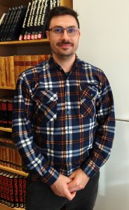 Omar, opiskelijamies seisoo kirjastotilassa.