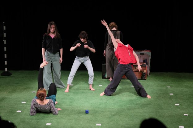 Viisi taitelijaa näyttämöllä.