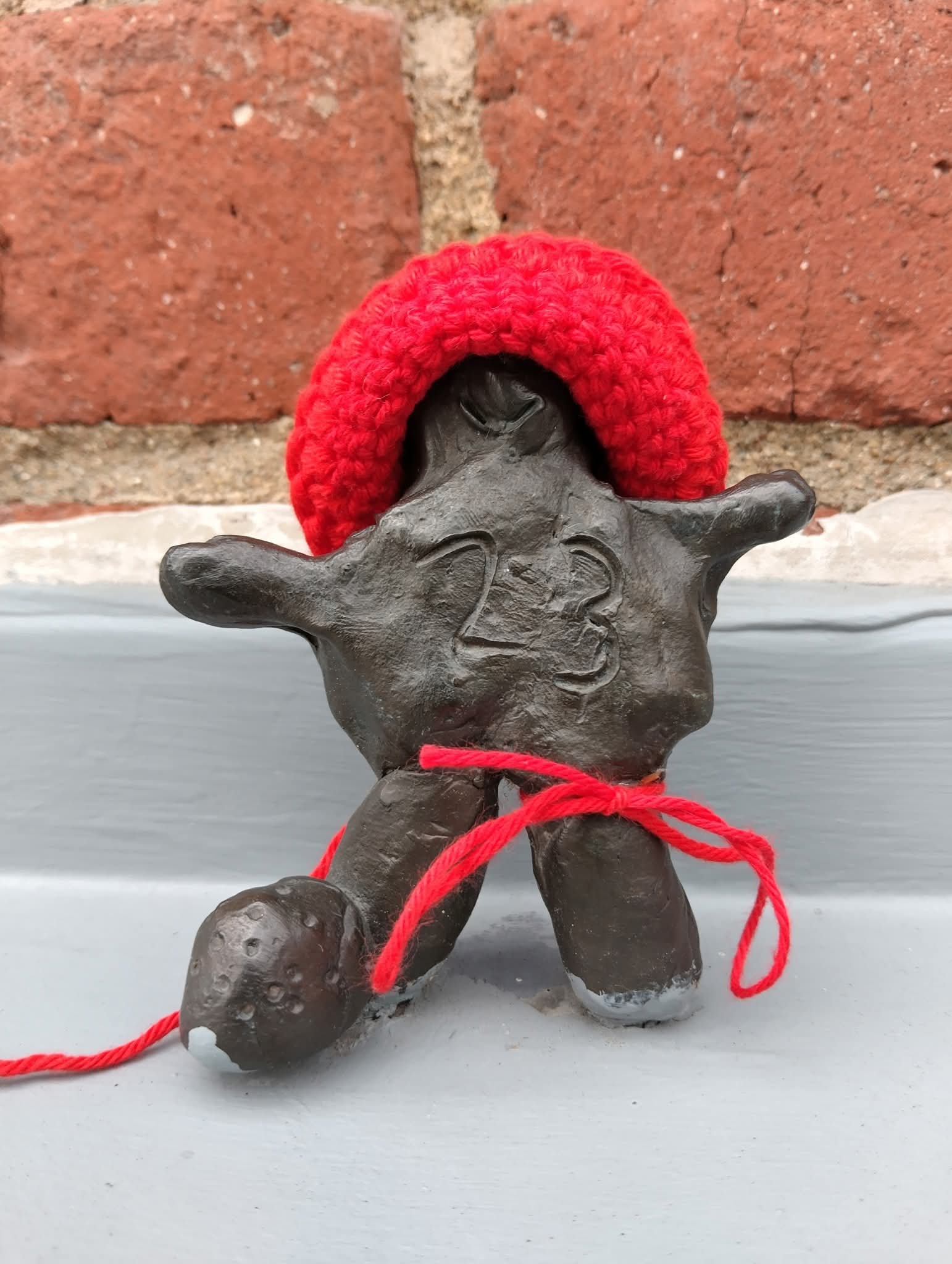 Peikko saanut päähänsä punaisen villahatun.