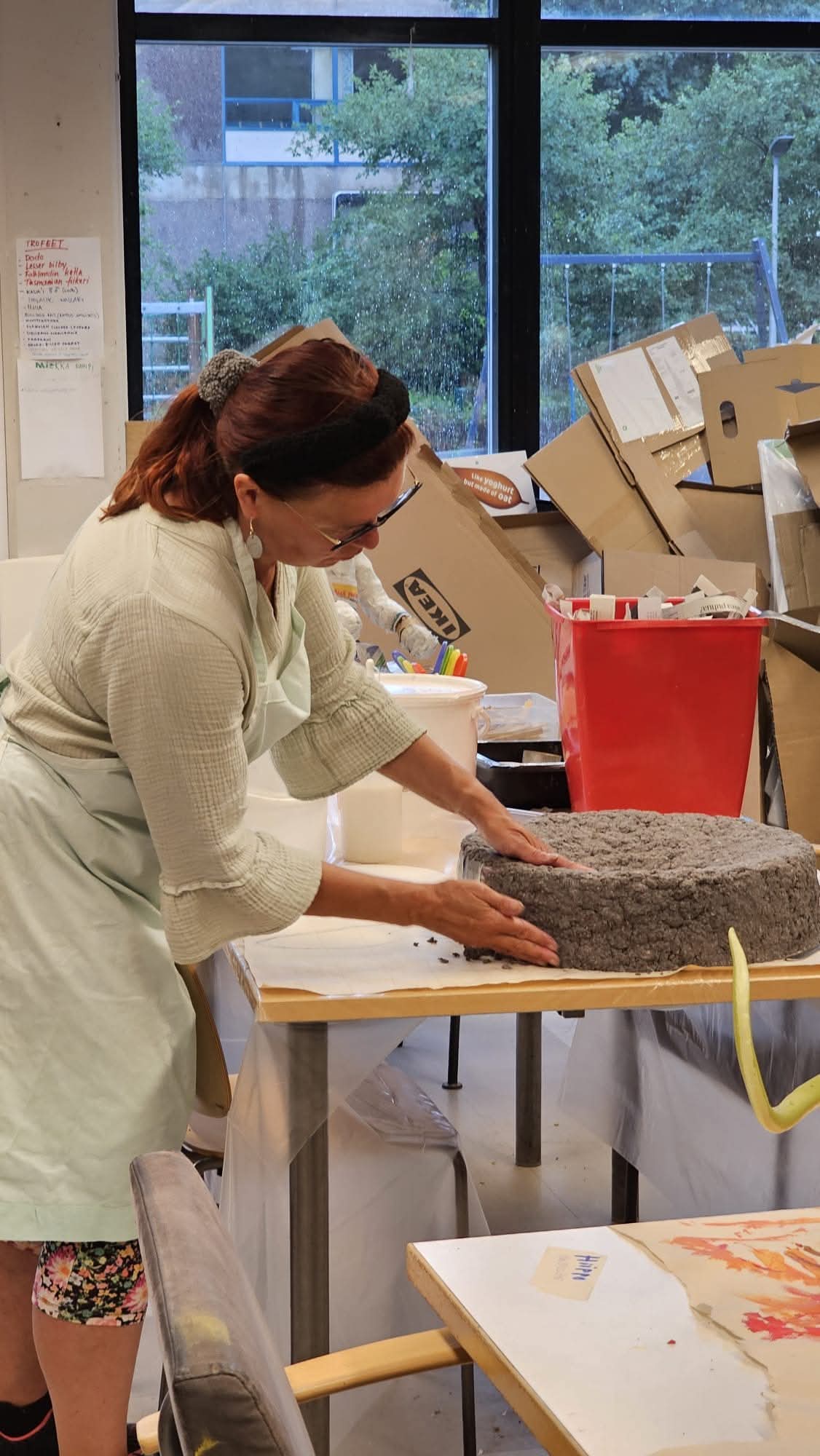 Henkilö muotoilee saven tapaista materiaalia.