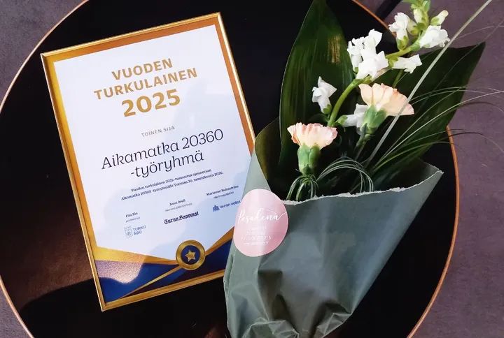 Vuoden Turkulainen 2025 -palkinto ja kukkakimppu.