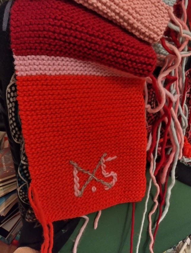 Raidallinen neuletyö, jossa teksti 1.5 yli ruksattuna.