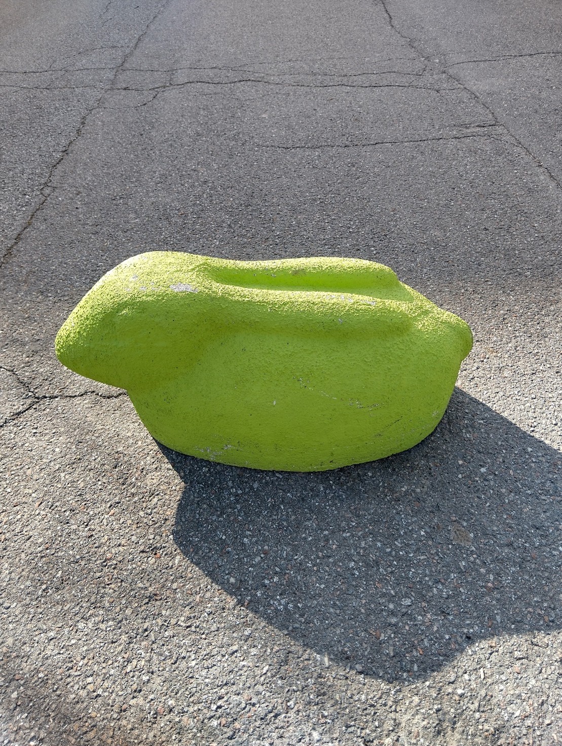 Kivinen vihreä pupu sykkyrällä maantiellä.