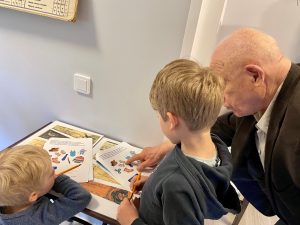 Pikkupoika ja isoisä tutkivat museossa vanhoja lehtiä. kuva: Come Stronger -hanke