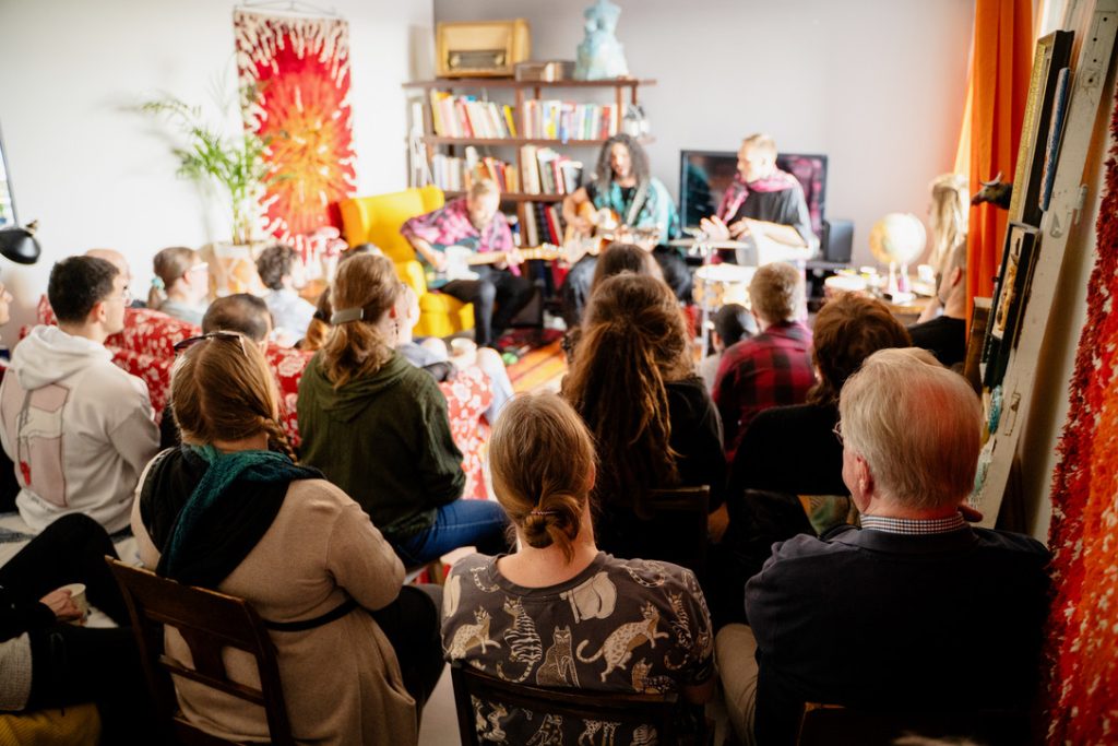 Kuvaaja on yleisön takana, kamera näyttää yleisön katsomassa musiikkiesitystä yksityiskohdissa.