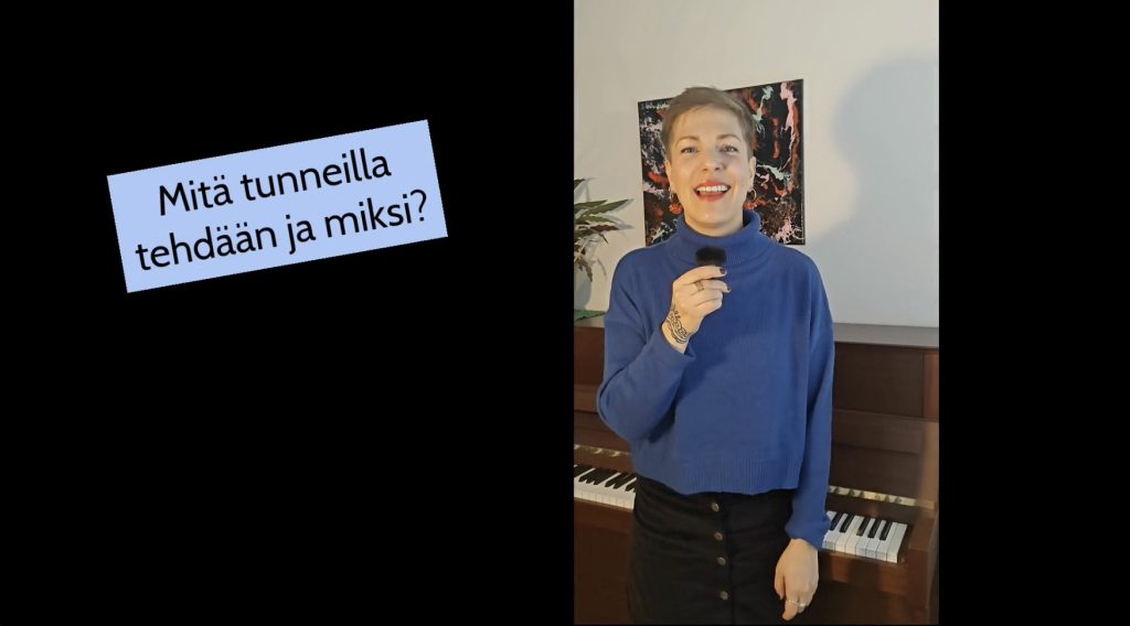 Kuvassa on Julia Vuorinen pianon edessä mikrofoni kädessään. Kuvassa on teksti: Mitä tunneilla tehdään ja miksi?