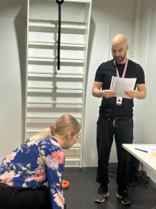 Fysioterapeutti ohjaa asiakkaalle palauttavaa liikettä.