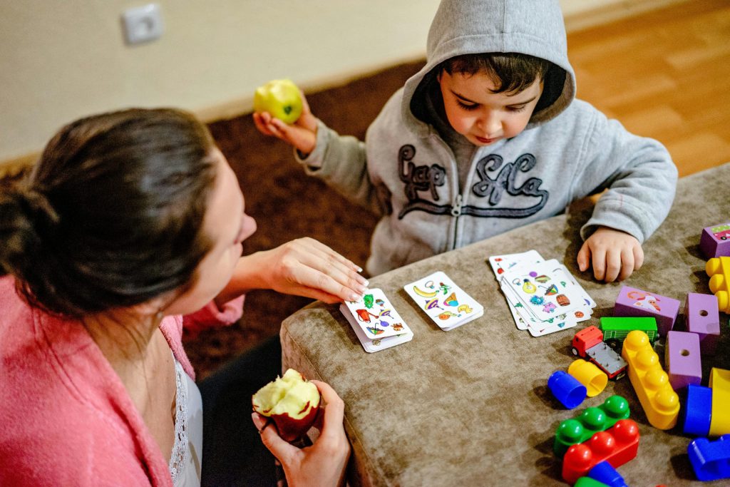 Lapsi ja aikuinen pelaavat korttipeliä. Pexels