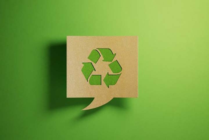 Kierrätyssymboli vihreällä taustalla