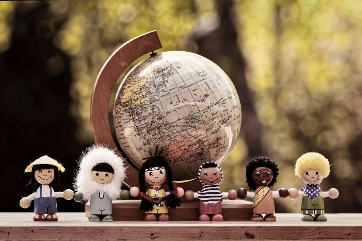 Monikulttuurisuutta kuvaavat puiset nukkehahmot ja maapallo taustalla