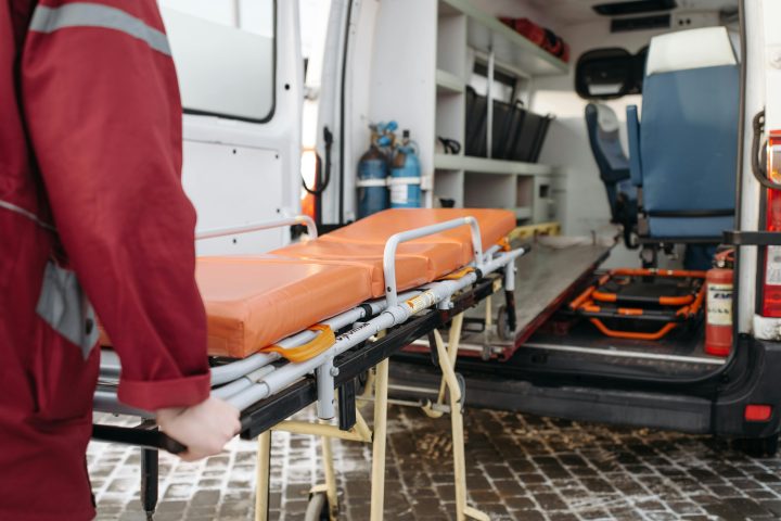 Ensihoitaja työntää parreja ambulanssin avoimesta ovesta sisään.