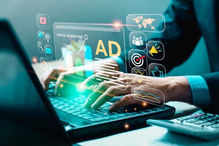 kädet läppärillä, etualalle heijastuu ikoneita tietokoneen ruudulta